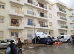 Vehicles piled beneath a damaged apartment building in Silves.